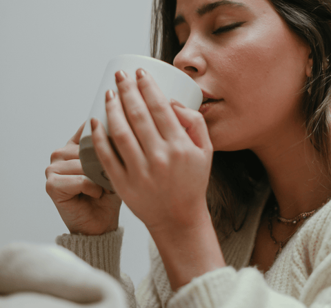 Woman drinks tea from a ceramic mug made with a DIY Pottery Kit